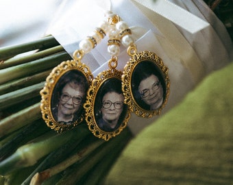 Puede incluir: Un ramo de flores verdes con tres marcos ovalados dorados unidos. Cada marco contiene una foto en blanco y negro de una mujer con gafas.