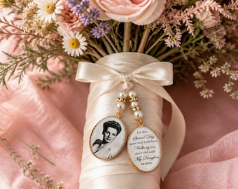 Puede incluir: Un ramo de novia con flores rosas y blancas, envuelto en cinta marfil. Dos colgantes ovalados con una foto y texto cuelgan de la cinta. El texto dice: "En este día especial, sé que estoy aquí, caminando hacia el altar, mi hija, mi querida."