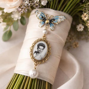 Un bellissimo ciondolo a forma di bouquet con foto color oro. Un ricordo prezioso a forma di farfalla con strass, perfetto come "qualcosa di blu" per la sposa nel giorno del suo matrimonio.