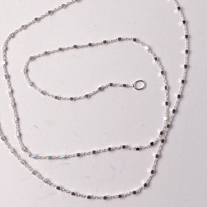 May include: A silver chain necklace with a square link pattern. The chain is about 18 inches long and has a lobster clasp.