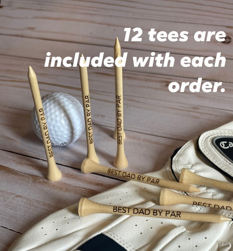 May include: A golf ball and wooden golf tees with the text "BEST DAD BY PAR". The image also includes a golf glove. The text "12 tees are included with each order" is also visible.