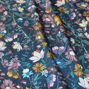 May include: A dark blue fabric with a floral pattern. The fabric features a variety of flowers in shades of pink, yellow, white, and blue.