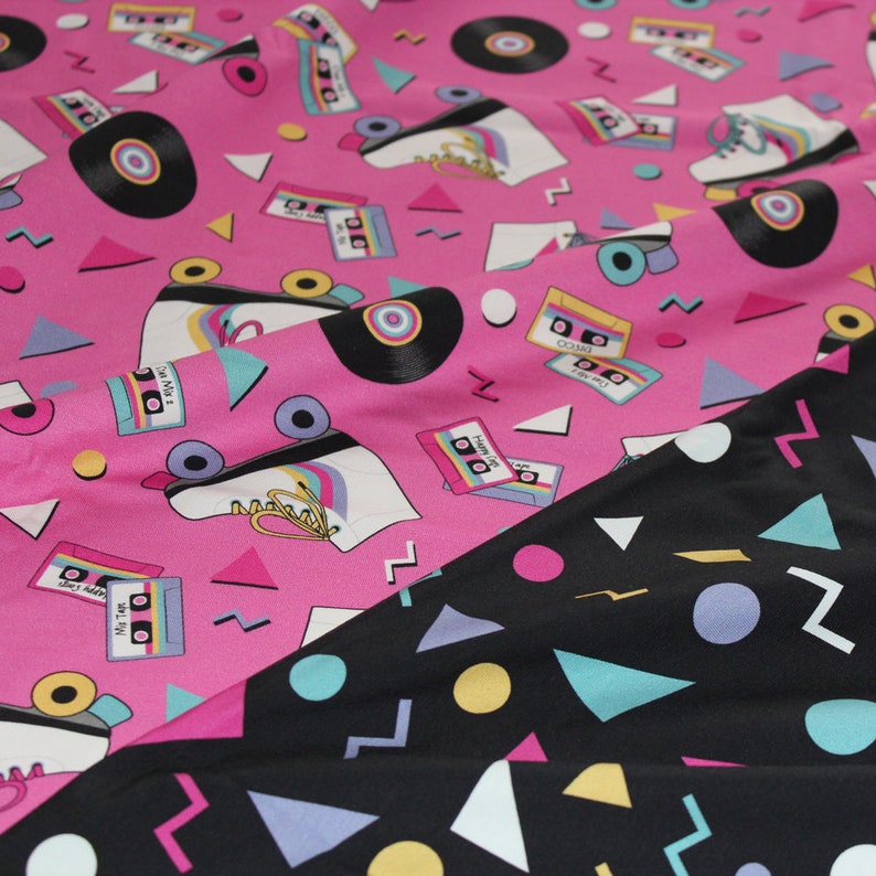 K&ouml;nnte beinhalten: Rosa Stoff mit einem sich wiederholenden Muster aus Rollschuhen, Kassetten und Schallplatten. Der Stoff ist &uuml;ber einen schwarzen Stoff mit einem geometrischen Muster aus Dreiecken, Kreisen und Zickzacklinien gefaltet.