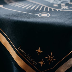 May include: Black velvet cloth with a gold geometric design and the text "lamuci design" in gold lettering.