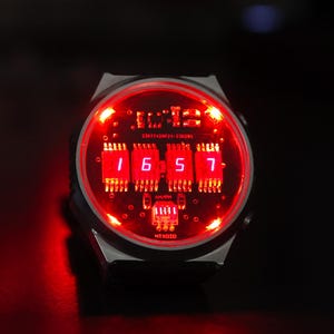 May include: Two digital watches with red LED displays. The watches have a futuristic design with a black strap and a red illuminated face. The background is dark, with red accent lighting.