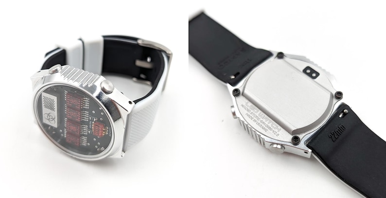 May include: A silver wristwatch with a white and black band. The watch face has a digital display with red numbers. The back of the watch has a silver case with black text.