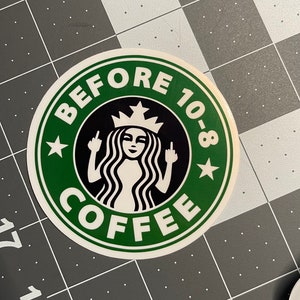 May include: A green and white sticker with a black and white illustration of a woman with a crown on her head giving the middle finger. The text on the sticker reads "Before 10-8 Coffee".