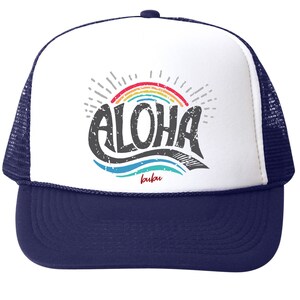 May include: Navy blue and white trucker hat with the word "ALOHA" in distressed gray lettering. A rainbow and sunburst design is above the word, with the word "bubu" in red below. The hat has a mesh back.