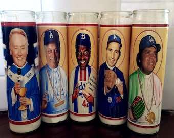 Op de afbeelding: Vijf glazen gebedskaarsen met portretten van honkballegendes. Elke kaars heeft een andere speler, waaronder St. Vin, en is versierd met teamkleuren en logo's. De kaarsen zijn cilindrisch en hebben een witte basis.