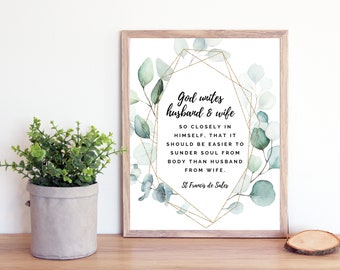 May include: A white framed print with a watercolor illustration of eucalyptus leaves and gold geometric shapes. The print features a quote about the bond between husband and wife, "God unites husband & wife so closely in himself, that it should be easier to sunder soul from body than husband from wife." - St Francis de Sales