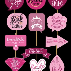 Op de afbeelding: Een verzameling roze fotohokjesrekwisieten met verschillende zinnen voor een vrijgezellenfeest. De rekwisieten bevatten tekstballonnen, harten en diamanten met teksten als "Bride to Be", "Bride Tribe" en "She Said Yes".