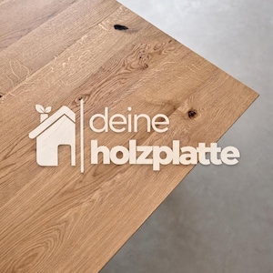 Könnte beinhalten: Nahaufnahme einer hellbraunen Holzoberfläche mit sichtbarer Holzmaserung. Der Text "deine holzplatte" ist in Weiß dargestellt. Ein Logo eines Hauses mit einem Blatt befindet sich links vom Text.