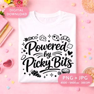 Könnte beinhalten: Weißes T-Shirt mit dem schwarzen Schriftzug "Powered by Picky Bits". Das Design beinhaltet Illustrationen von Käse, einem Croissant, Trauben und anderen Lebensmitteln. Digitaler Download in PNG- und JPG-Formaten.