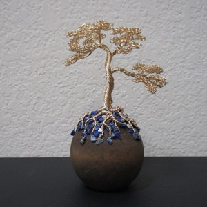 Golden tree rooted on wooden ball