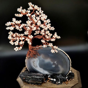 Könnte beinhalten: Ein Set aus drei Keramikbechern mit gesprenkelter, matter Oberfläche. Die Becher sind in Creme-, Hellgrau- und Dunkelgrautönen gehalten. Jeder Becher hat ein schlichtes, minimalistisches Design und einen abgerundeten Henkel. Für Kaffee oder Tee.