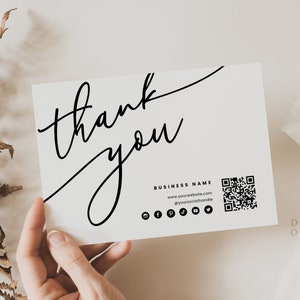 May include: A white thank you card with black calligraphy that says "thank you". The card also includes a business name, website address, social media icons, and a QR code.