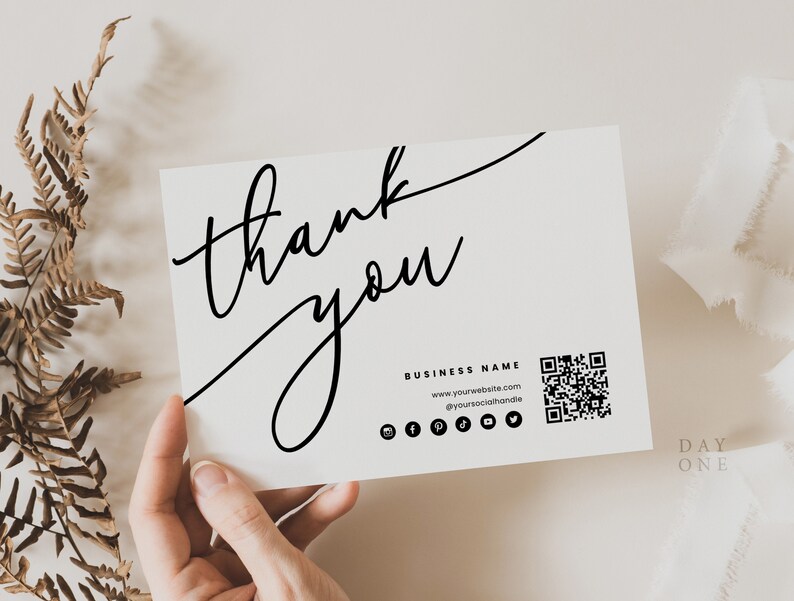 May include: A white thank you card with black calligraphy that says "thank you". The card also includes a business name, website address, social media icons, and a QR code.
