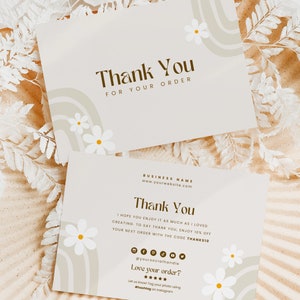 May include: Two thank you cards with a light brown background and white daisies. The top card says "Thank You for Your Order". The bottom card says "Thank You" and includes a business name, website address, and a discount code.