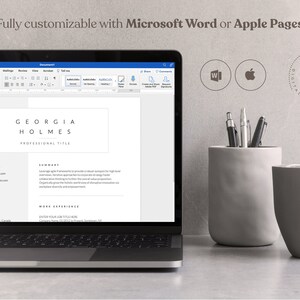 May include: A laptop computer displaying a resume template with the text "GEORGIA HOLMES PROFESSIONAL TITLE" on the screen. The laptop is on a gray surface with a gray pencil holder and a gray cup.