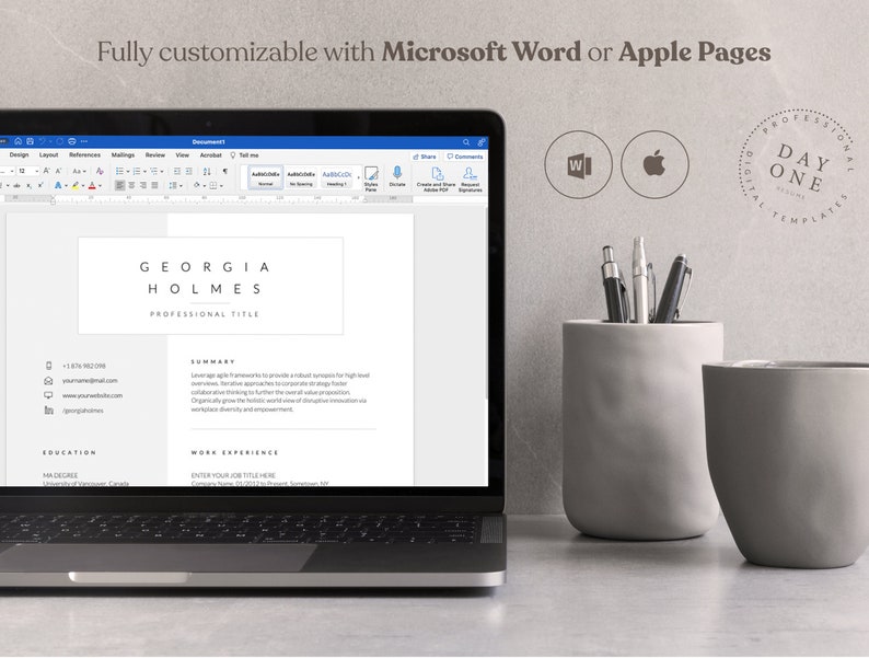 May include: A laptop computer displaying a resume template with the text "GEORGIA HOLMES PROFESSIONAL TITLE" on the screen. The laptop is on a gray surface with a gray pencil holder and a gray cup.