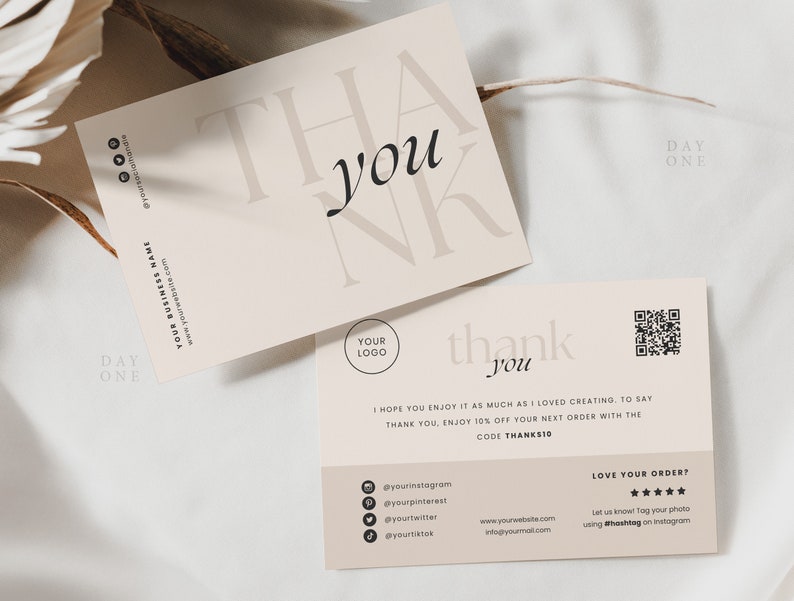 Op de afbeelding: Een bedankkaart met een minimalistisch ontwerp met de woorden "dankjewel" in beige op een cr&egrave;mekleurige achtergrond. De kaart bevat een QR-code, social media-iconen en een website-adres.