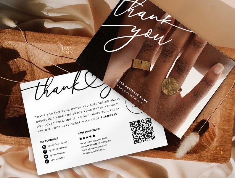 K&ouml;nnte beinhalten: Eine Dankeskarte im Schwarz-Wei&szlig;-Design. Die Karte zeigt eine Hand, die zwei goldene Ringe tr&auml;gt. Der Text auf der Karte lautet "Danke" und enth&auml;lt einen QR-Code sowie Social-Media-Handles. Die Karte enth&auml;lt au&szlig;erdem den Text "YOUR BUSINESS NAME" und "www.yourwebsite.com".