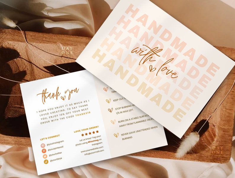 May include: A white card with the text "Handmade with love" in a gradient of peach and orange. The card also includes instructions for burning candles, a thank you message, and social media handles.
