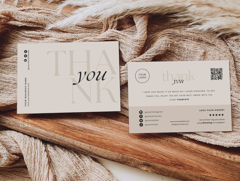 Op de afbeelding: Een bedankkaart met een eenvoudig ontwerp in beige en zwart. De kaart zegt "Bedankt" in een gestileerd lettertype. De achterkant van de kaart heeft een QR-code, social media-iconen en de tekst "Ik hoop dat je er net zo van geniet als ik van het maken. Om je te bedanken, krijg je 15% korting op je volgende bestelling met de code THANKS15".