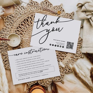 May include: White thank you card with black calligraphy text, care instructions, and business name. The card includes a QR code and social media icons. The card is on a woven straw mat.