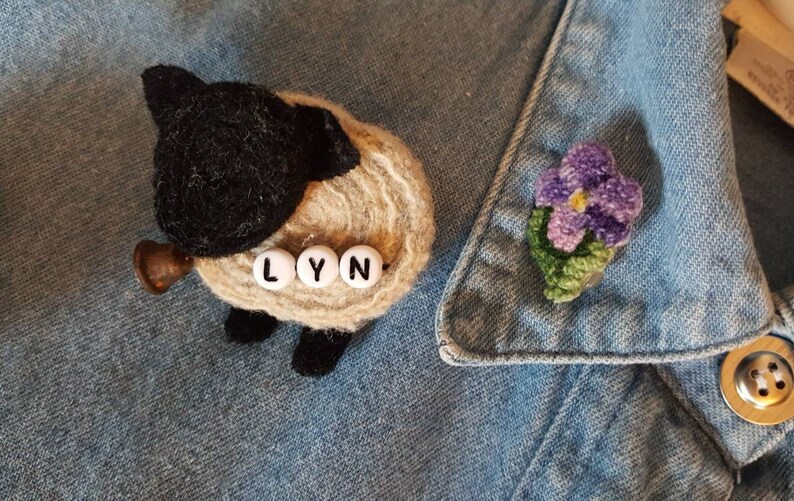 11 Vintage Handmade Felting and Rug Hooked Pins on Denim Shirt.