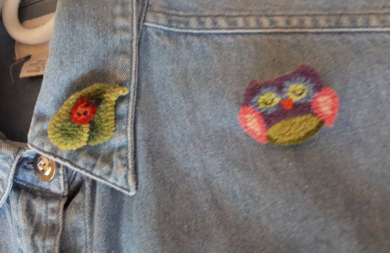 11 Vintage Handmade Felting and Rug Hooked Pins on Denim Shirt.