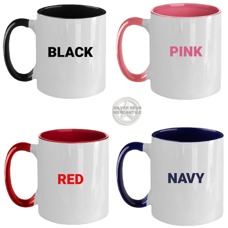 Puede incluir: Cuatro tazas de cer&aacute;mica con bordes y asas de diferentes colores. Las tazas son blancas con las palabras "BLACK", "PINK", "RED" y "NAVY" impresas en el color correspondiente en cada taza.
