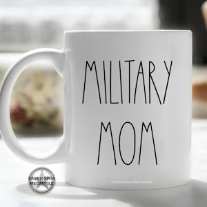 May include: White ceramic coffee mug with black text that reads "Military Mom".
