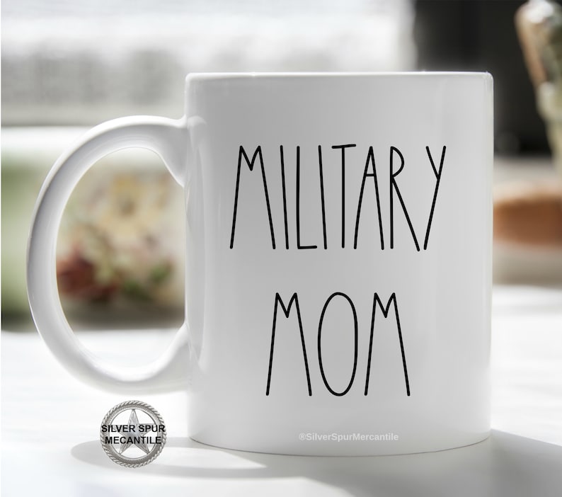 May include: White ceramic coffee mug with black text that reads "Military Mom".