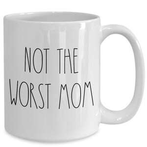 May include: White ceramic coffee mug with black text that reads "Not the worst mom".