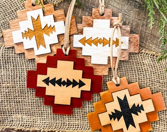 May include: Four wooden ornaments with geometric patterns in shades of brown, white, and red. The ornaments are shaped like crosses and feature different geometric designs.