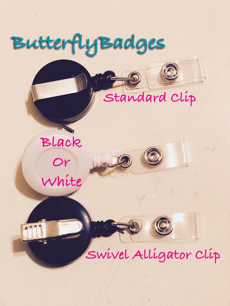 May include: Three retractable badge holders are shown. The top and bottom holders are black, and the middle one is white. The top holder has a standard clip, the middle one says "Black Or White", and the bottom one has a swivel alligator clip. The text "ButterflyBadges" is at the top.