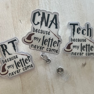 May include: Three clear badge reels with text. The badges say "RT because my letter never came", "CNA because my letter never came", and "Tech because my letter never came". Each badge has a wizard hat and wand design.