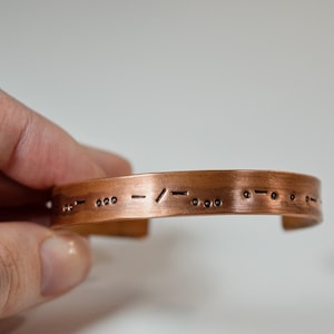 以下が含まれることがあります： 点字でメッセージが刻まれた銅製のブレスレット