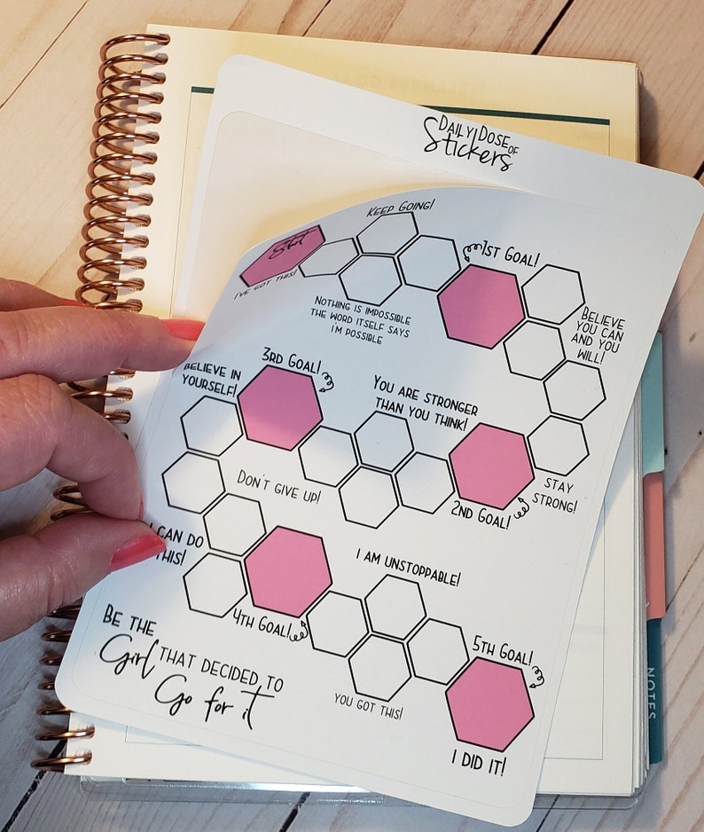 May include: A white sticker with a honeycomb design and pink motivational messages. The sticker says "Keep Going!" and "1st Goal!" at the top. The sticker also includes messages like "Believe in Yourself!" and "You Got This!"