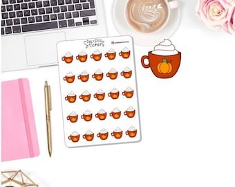 May include: A sheet of stickers featuring a cartoon pumpkin spice latte design. The stickers are brown with a pumpkin graphic and white whipped cream. The sheet is next to a laptop, pen, and pink notebook.