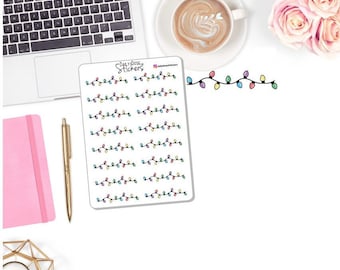 May include: A sheet of stickers featuring colorful string lights. Each sticker has a black line with multiple colored bulbs. The stickers are on a white background with a laptop, pen, and coffee cup.