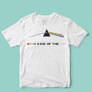 Pu&ograve; includere: Maglietta bianca con un prisma arcobaleno e un gatto rosa con un fumetto che dice "NYAN". Il testo sotto il prisma dice "NYAN SIDE OF THE CAT".