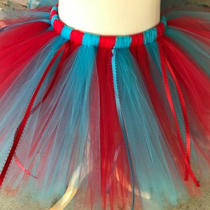 Puede incluir: Una vibrante falda tut&uacute; de tul rojo y azul claro. La cintura est&aacute; a rayas rojas y azul claro. Se adjuntan cintas rojas y azul claro a la falda, lo que se suma al dise&ntilde;o l&uacute;dico. Esta falda es adecuada para bailar o disfrazarse.