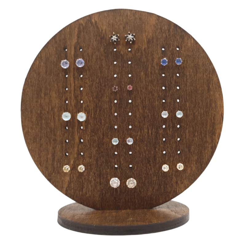 May include: A wooden earring display stand with multiple rows of colourful gemstone earrings. The stand is circular with a base and features a variety of colours, including blue, pink, and white.