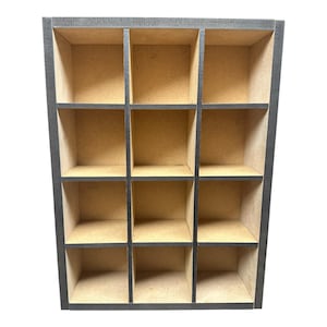 May include: A rectangular wooden display shelf featuring twelve individual square compartments arranged in a four-row by three-column grid. The outer frame and internal dividers are finished in a dark charcoal grey, while the interior surfaces.