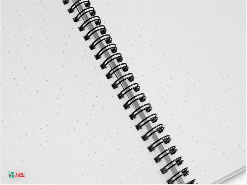 a black and white spiral notebook on a white surface