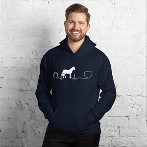 May include: A navy blue hoodie with a white horseshoe, a white horse, a white heart, and a white heartbeat line graphic. The graphic reads "Horseshoe Heartbeat".