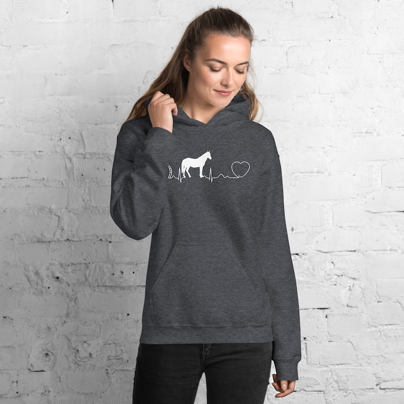 May include: A dark grey hooded sweatshirt with a white horse silhouette and a heartbeat graphic. The graphic includes a heart symbol and the text "I love horses".