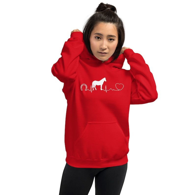 May include: Red hoodie with a white silhouette of a horse, a horseshoe, and a heart with a heartbeat line. The text reads "My heart beats for horses".